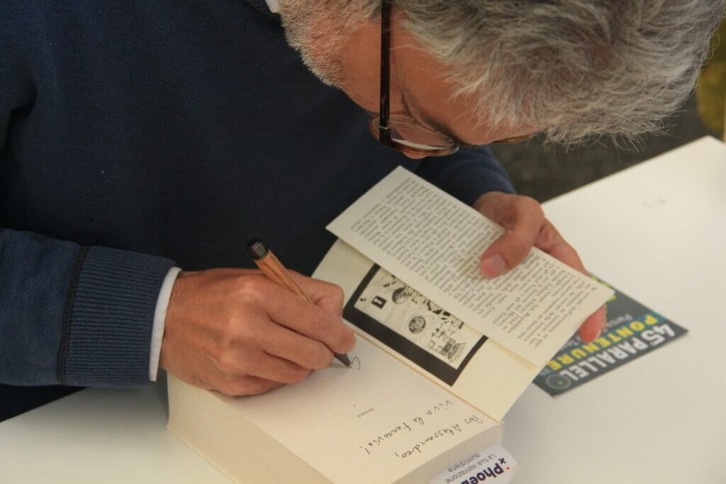 The Italian autgor Gian Mario Griffi signs an autograph at the Turin International Book Fair